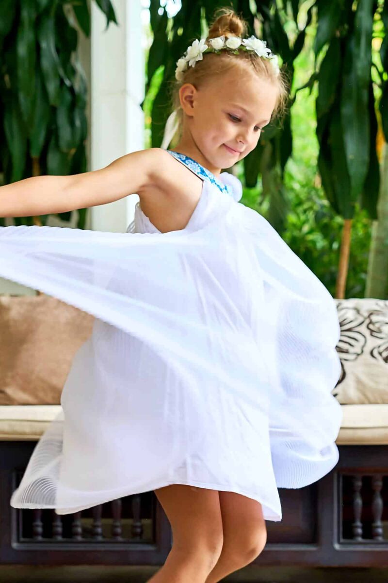 Magnifique robe qui tourne de cérémonie en voile blanc et col arrondi en coton fleuri liberty bleu roi. De forme ample et fluide